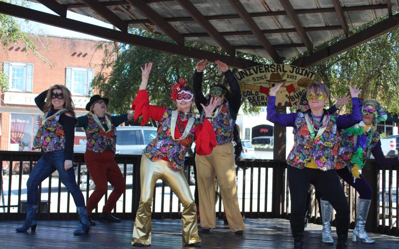Megan Broome/The Clayton Tribune. Nadine Bramlett, left, Cindy Chlupacek, Debbie Martin, Dina Vinson, Mary Baer and Sharon Purdy of the Rabun Entertainers group performs a flash mob to the tune of "Footloose" on the stage of Universal Joint for Mardi Gras.
