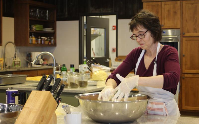 Megan Broome/The Clayton Tribune. Inger Smith, Teaching Kitchen manager, works with Food Bank staff and volunteers in the kitchen to prepare meals for first responders and healthcare personnel on Wednesday.