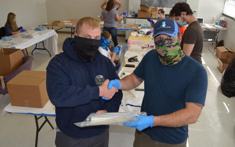 Wayne Knuckles/The Clayton Tribune. Clayton Mayor Jordan Green, left, signed an agreement with Shaun Brautigan Monday to allow his company to use the city's Community Room to produce face shields.