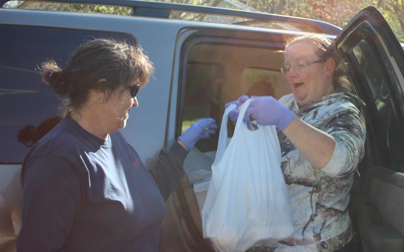 Megan Broome/The Clayton Tribune. Shannon Speed, left, and Melissa White distribute meals to elderly Rabun County residents on Monday as part of the Meals on Wheels program run by the Rabun County Senior Center. Enough meals for five days are being delivered by employees on Mondays in order to limit potential exposure of the COVD-19 virus to elderly residents.