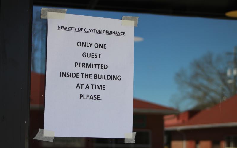 Megan Broome/The Clayton Tribune Fortify Pi, a restaurant located on Main Street in Clayton, had this sign posted on their window last Wednesday afternoon. The Clayton council proclaimed that businesses operating inside the city should limit the number of people in their establishments at any one time to one person per 100 square-feet of floor space, not including store employees.