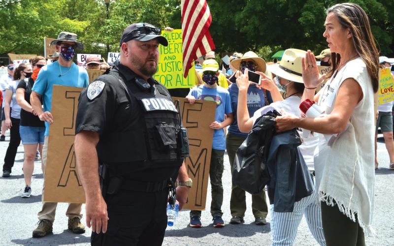 Wayne Knuckles/The Clayton Tribune. Clayton Police Chief Andy Strait, left, talks with vigil organizer Sarah Gillespie before the start of Saturday's Silent March.