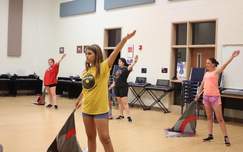 Color guard members Desirhae Buice, left, Gracie Pickens, Kristin English and Leizle Mason practice during sectionals at band camp last week.