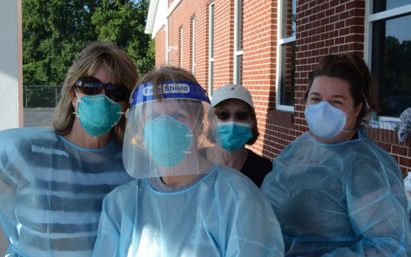 Wayne Knuckles/The Clayton Tribune. Cathy Mummaw, Toshia Hughes and Carmen Rodgers, along with Rabun County Health Department Office Manager Sue Darnell, prepare to administer free COVID-19 tests at Clayton First Baptist Church Tuesday morning.