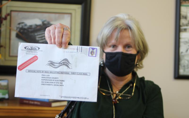 Megan Broome/The Clayton Tribune. Voter Pamela Wawrzyk holds up an absentee ballot that was returned by the post office for an unknown reason. She said that she and her husband Stephen found the ballot in their mailbox when they came back from Florida and it had no indication of the reason it was returned. She cautioned voters to be sure and check their ballot status to make sure their ballot is received by the elections office for their vote to be counted.