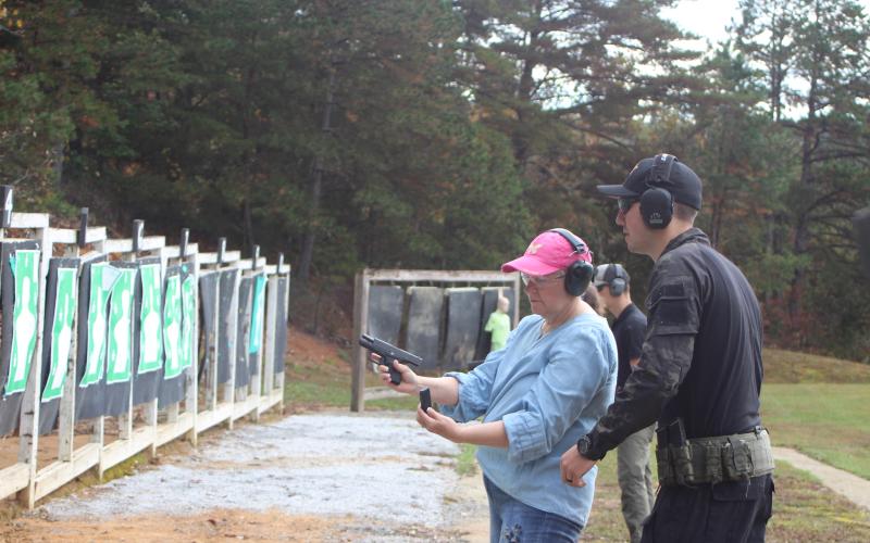 Megan Broome/The Clayton Tribune. Deputy Clinton Scott helps Lt. Gerrells instruct the Level 2 Firearms Training Group in training exercises to practice shooting at a moving target at the Sheriff's Office training center last Saturday.