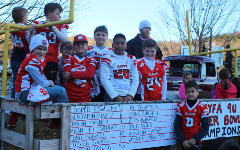 Megan Broome/The Clayton Tribune. Players for the 9U football team division in the North Georgia Youth Football Association are 2020 Superbowl Champions. They pose for a photograph on their float before the start of the Christmas parade last Saturday. This same team was the 2019 Superbowl winner when they competed in the 8U division last year.