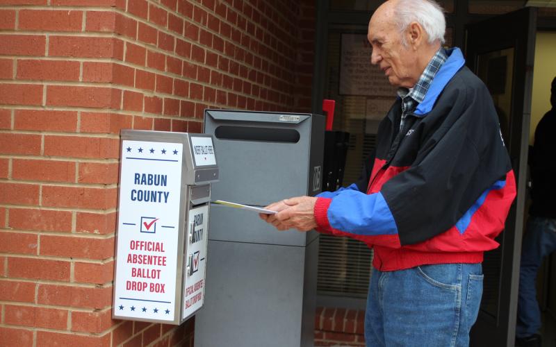 Megan Broome/The Clayton Tribune. Voter J.P. Miles returns his absentee ballot to the designated box in front of the Board of Elections Office on Monday. The office is located at 18 Old Raco Dr., Suite 105, Clayton.