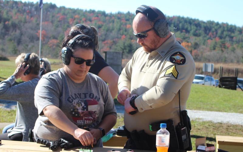 Megan Broome/The Clayton Tribune. Sgt. Riley Owens, right, assists Amber Owens with loading her gun at the Level 3 Firearms Course organized by the Rabun County Sheriff’s Office last weekend.