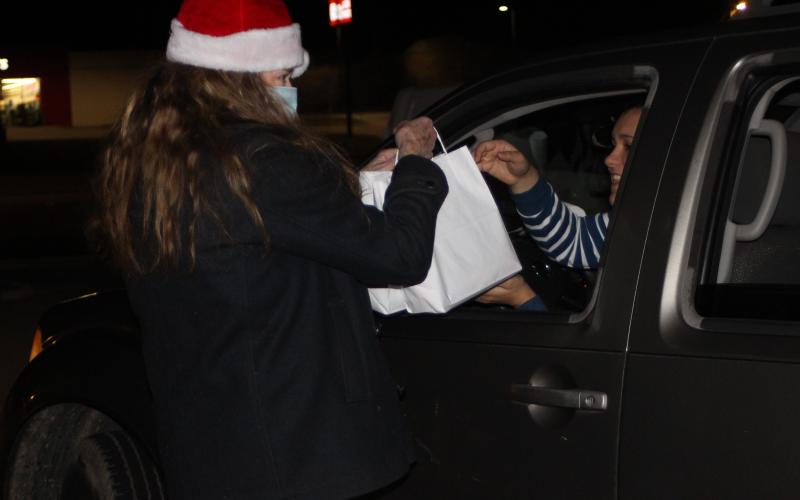 Megan Broome/The Clayton Tribune. Brenda Nash hands out holiday treat bags at the Food Bank of Northeast Georgia on Monday.