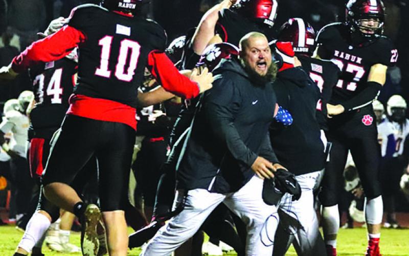 Rabun County Assistant Coach JayJay White joins the celebration after the Wildcats defeated Bleckley 27-24 in overtime last week. The Wildcats need to win one more game Friday night to earn the right to travel to Atlanta and play for a state championship.