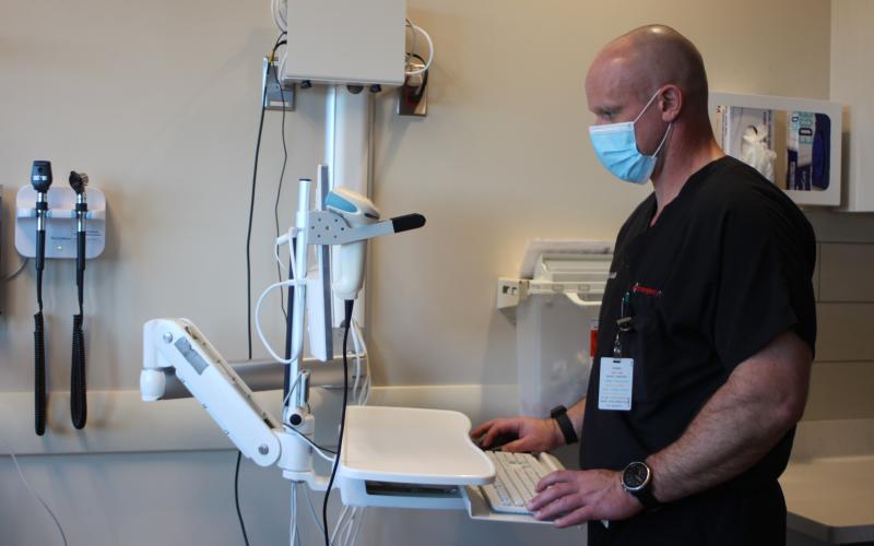 Megan Broome/The Clayton Tribune. Dr. Jason Blasenak, emergency department physician, works on a computer in a patient's room in the emergency department at Mountain Lakes Medical Center.