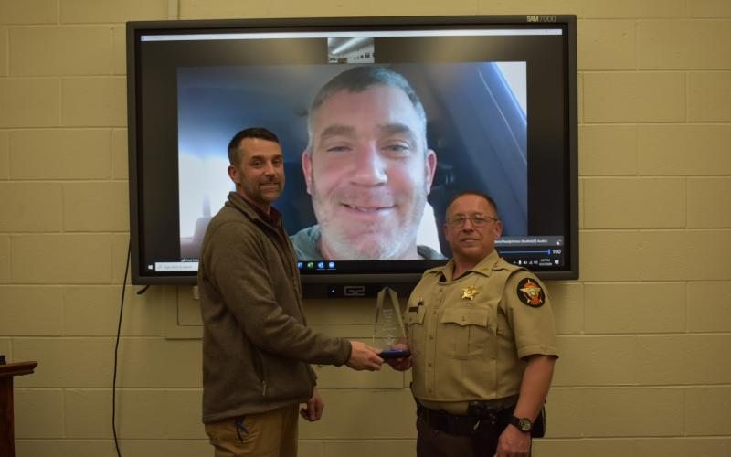 Photo courtesy Rabun County Sheriff’s Office. Chief Deputy Scott Cheek, left, presents the Deputy of the Year award to Deputy Tony Parrish in December. Sheriff Chad Nichols participates via video call.