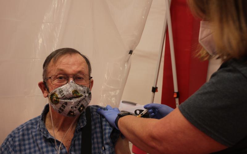 Megan Broome/The Clayton Tribune. Rabun County EMT Stephanie Quilliams gives James Allen a COVID-19 vaccine at Tuesday’s clinic held at the Rabun County Recreation Department.