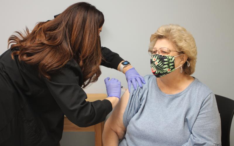 Megan Broome/The Clayton Tribune. Trisha Jones, RN, left, at Medlink gives a COVID-19 vaccination to Melissa Evans last Friday.
