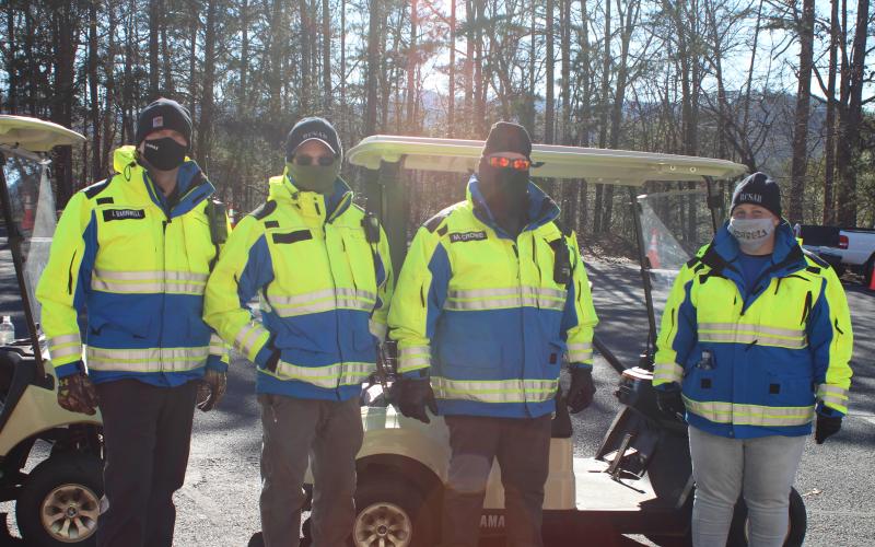 Megan Broome/The Clayton Tribune. Jon Barnwell, left, John Lovelady, Michael Crowe and Kim Beck with Rabun County EMA transport patients in golf carts to the vaccine clinic held at the Rabun County Parks and Recreation Department on Tuesday.
