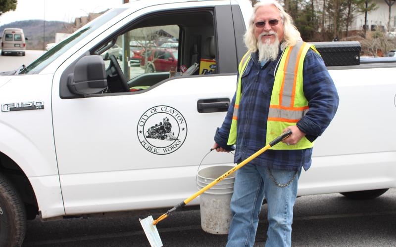 Megan Broome/The Clayton Tribune. Rob Hawsey picks up trash on Main Street in downtown Clayton with a grabber tool on Tuesday. He said that this and a broom are the materials he uses most for his job. Hawsey works for the city of Clayton as a street crew member under the Public Works Division.