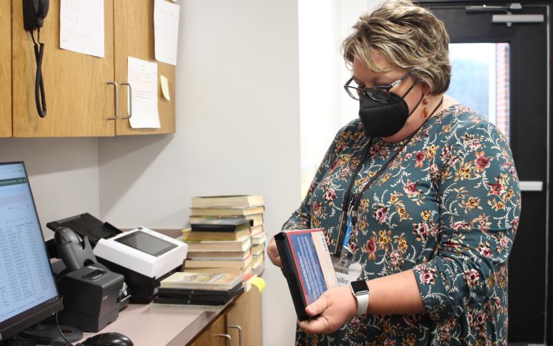 Megan Broome/The Clayton Tribune. Circulation Supervisor Jennifer Buchanan organizes the inventory that’s been returned to the library behind the circulation counter on Tuesday.