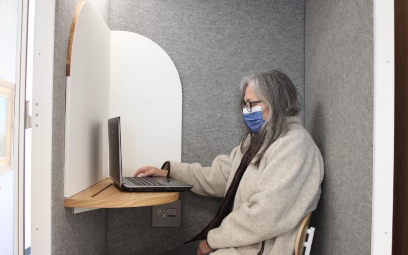 Megan Broome/The Clayton Tribune. Library patron Marce Lacouture utilizes one of the new pods for a video-conferencing call on Monday.