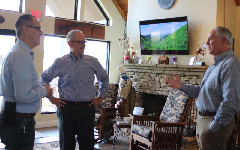Megan Broome/The Clayton Tribune. Michael Esposito, city manager for the city of Clayton, left, and Rick Story, director of development for Rabun County, right, converse with new chamber President Cliff Bussard at a meet-and-greet event held at the Rabun County Welcome Center on Monday.