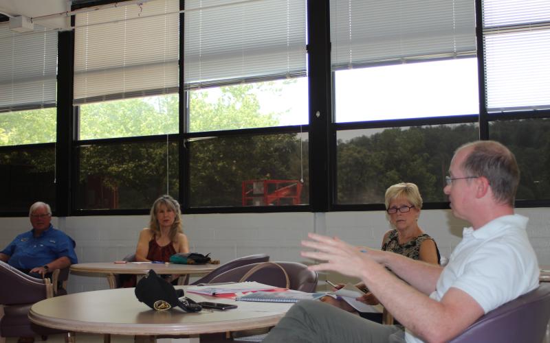 Megan Broome/The Clayton Tribune. Clayton DDA members Karen Bacon, vice chair, and Cassandra Clouser, board chair, listen to guest speaker Adam Hazell, planning director for the Georgia Mountains Regional Commission, talk about how to best organize their projects to make improvements to areas of downtown Clayton.