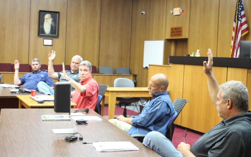 Megan Broome/The Clayton Tribune. Commissioners Will Nichols, left, Kent Woerner, Chairman Greg James, and Tom Garrison, far right, vote to approve a rezoning request from Taywood, LLC to rezone the property 8118 Bridge Creek Rd. from Agricultural to Commercial Business at Tuesday’s commission meeting. Commissioner Scott Crane voted against the motion.