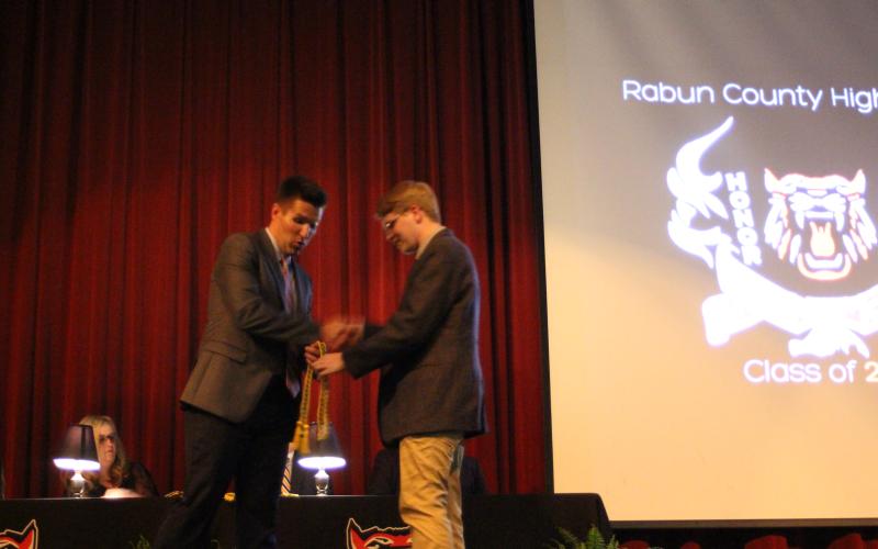 Megan Broome/The Clayton Tribune. RCHS Principal Justin Spillers, left, presents graduate Chandler Hensley with his awards at Senior Scholarship and Awards Night held in the Fine Arts Building auditorium on May 11.