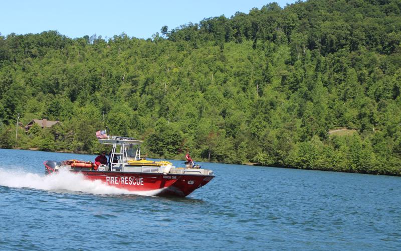 Megan Broome/The Clayton Tribune. The Rabun County Fire Services fire boat led the parade of wooden boats in the annual Lake Burton Wooden Boat Parade on Sunday. The boats set sail from Timpson Cove and made their way to LaPrade’s Marina where members of the public were invited to view the boats.