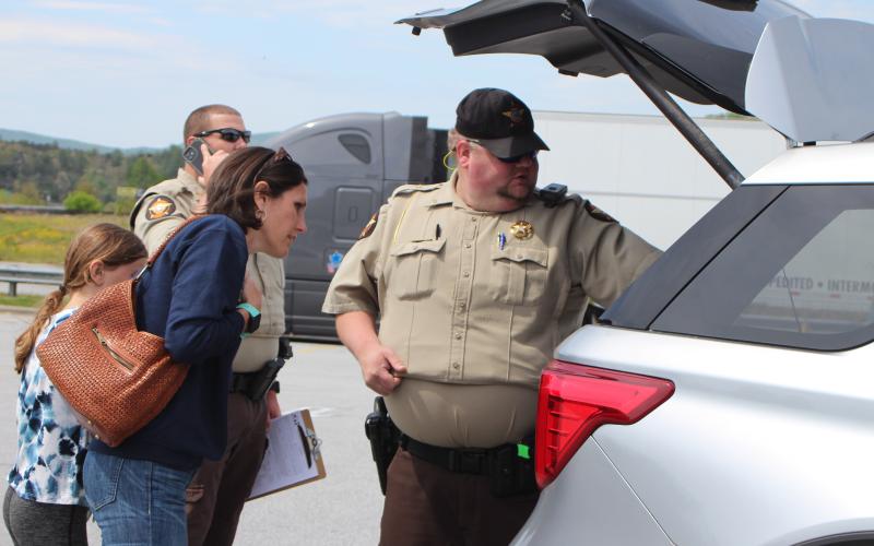 Megan Broome/The Clayton Tribune. Rabun County Sheriff's Office (RCSO) Patrol Corporal Andy Beck, right, discusses how to properly install a car seat with parent Kiana Miles at the Car Seat Inspection event at the Clayton Walmart recently. The RCSO partnered with Safe Kids Rabun County and nationally certified technicians helped citizens properly install car seats and booster seats. Beck was one of five deputies who became certified as a Child Passenger Safety Technician (CPST).