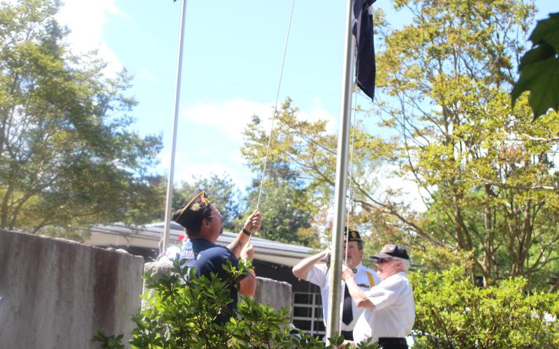 Megan Broome/The Clayton Tribune. Carl Green, Cdr American Legion Post 220 and Adam Swiencicki, VFW Post 4570, raised the flag and then lowered it to half mast at the Memorial Day ceremony held at the Rabun County Courthouse on Monday.