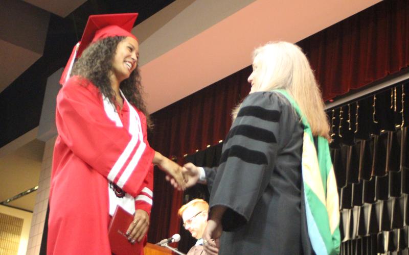 Megan Broome/The Clayton Tribune. Graduate Rissa McDonald shakes hands with Superintendent April Childers after receiving her diploma at last Friday’s ceremony.