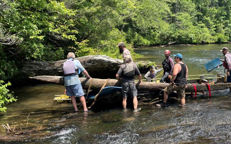 Submitted photo. A canoe found in the Chattooga River last year has been identified by the South Carolina Institute of Archeology and Anthropology as a 200-year-old artifact possibly made by Cherokee Indians or early European traders. Local nonprofit Chattooga Conservancy is working with the Forest Service to remove the canoe from the river and preserve it. A group of volunteers works to transfer the canoe into a protective cradle earlier this month.