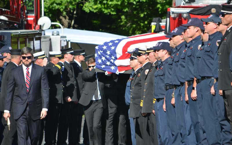 Wayne Knuckles/The Clayton Tribune. Rev. Joey Thompson, Senior Pastor at First Baptist Church of Clayton, leads the procession for firefighter Chandler Breck Patterson Friday afternoon at Betty's Creek Baptist Church.