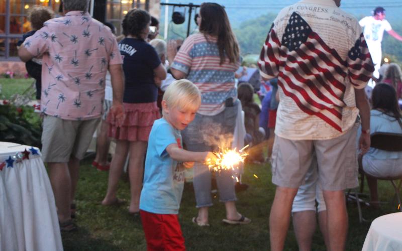 Megan Broome/The Clayton Tribune. Ethan Highouse,6, plays with a sparkler at The Dillard House on Sunday.