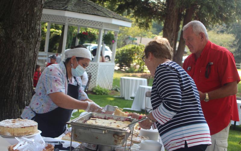 Megan Broome/The Clayton Tribune. Karen Harrison and Garrison Baker attend Fourth of July festivities at The Dillard House on Sunday. Aurora Quintana serves guests at the event.