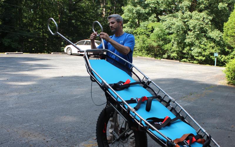 Megan Broome/The Clayton Tribune. Rabun County Search and Rescue Lt. Chris Wright demonstrates how a Stokes Basket is used to transport patients through various types of terrain when they are rescued.