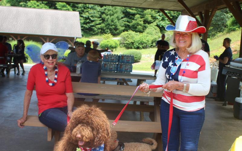 Megan Broome/The Clayton Tribune. Susan Williams, left, dog Curly Bear and Jeannette Brand celebrate the Fourth of July by participating in patriotic activities in Sky Valley on Saturday.