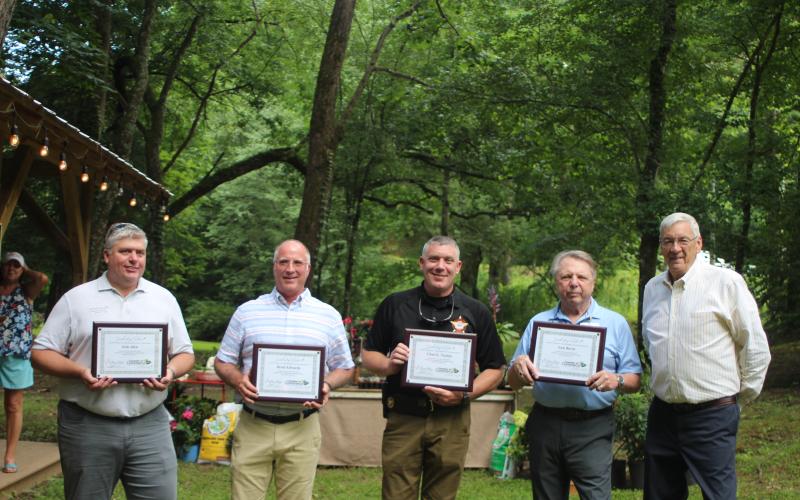 Megan Broome/The Clayton Tribune. Leadership Rabun participants Josh Allen with Habersham EMC, left, Brent Edwards with Georgia Power, Chad Nichols with the Rabun County Sheriff’s Office and Sam Burns of the Rabun County Republican Party are handed their certificates of completion of the program by Tony Allred, former president of the Rabun County Chamber of Commerce at the Chamber’s after-hours event in Lakemont last month.