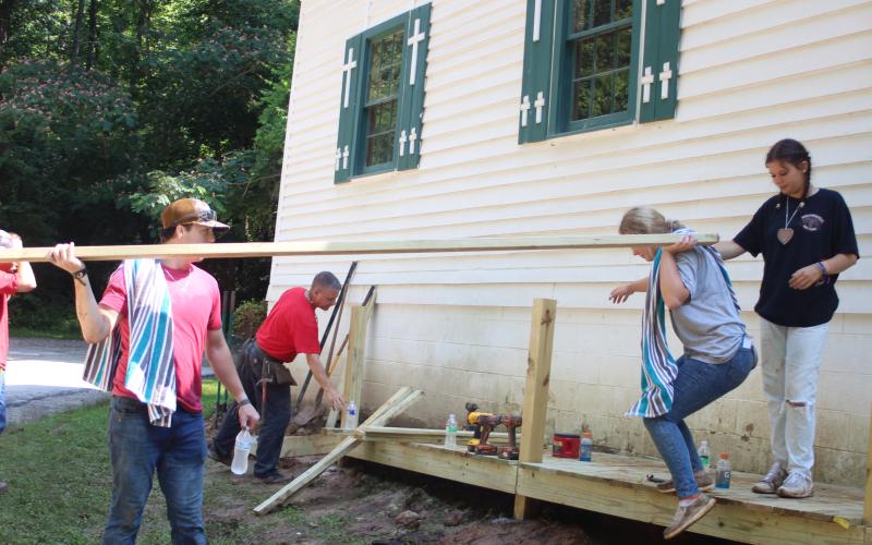 Megan Broome/The Clayton Tribune. Will Davis, left, Rev. Lee Krivsky, pastor at New Hope United Methodist Church, back, Stella Merkle and Hannah Hickox work to build a ramp to improve accessibility at New Hope United Methodist Church last month as part of the Rabun Aid Program (RAP).