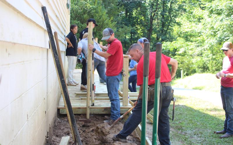 Megan Broome/The Clayton Tribune. Hannah Hickox, back left, David Riley, Stella Merkle, Evan Williamson, Chris Fuller and Rev. Lee Krivsky, pastor at New Hope United Methodist Church, work on the shoveling dirt to build the ramp to improve accessibility at New Hope United Methodist Church.