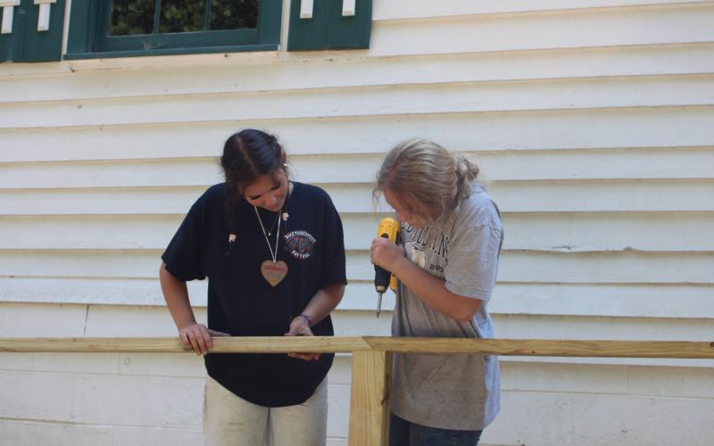 Megan Broome/The Clayton Tribune. Hannah Hickox and Stella Merkle participate in RAP and help build the ramp to improve accessibility at New Hope United Methodist Church last month.
