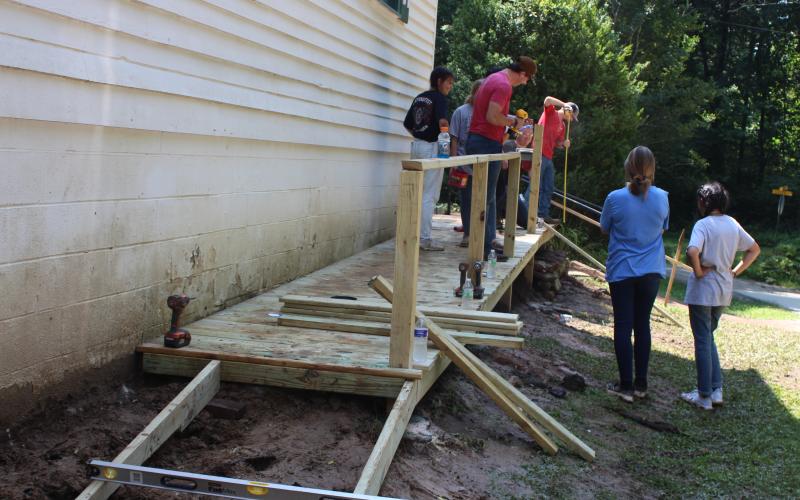 Megan Broome/The Clayton Tribune. Students from youth groups around the state help build a ramp to improve accessibility at New Hope United Methodist Church last month as part of the Rabun Aid Program (RAP). It was the 30th year of RAP and gives students the opportunity to help citizens in need in Rabun County and complete community service projects.