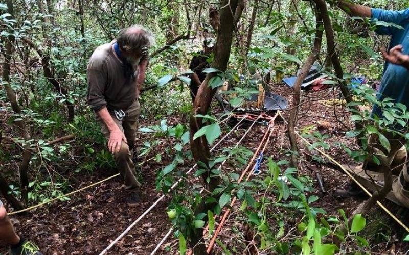 Submitted photo. Buzz Williams, a Chattooga Conservancy program associate, foreground, observes as an antique hand-carved wooden canoe is lowered down a ridge.