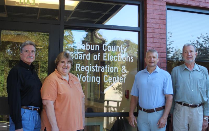 Megan Broome/The Clayton Tribune. Greg James, chairman of the Rabun County Board of Commissioners, left, Tammy Whitmire, Rabun County elections supervisor, Darrin Giles, Rabun County administrator, and Roy Lovell, Rabun County elections board member, pose in front of the new Rabun County Board of Elections Office. The new office is at 184 S. Main St. Suite 102, Clayton (below the health department).