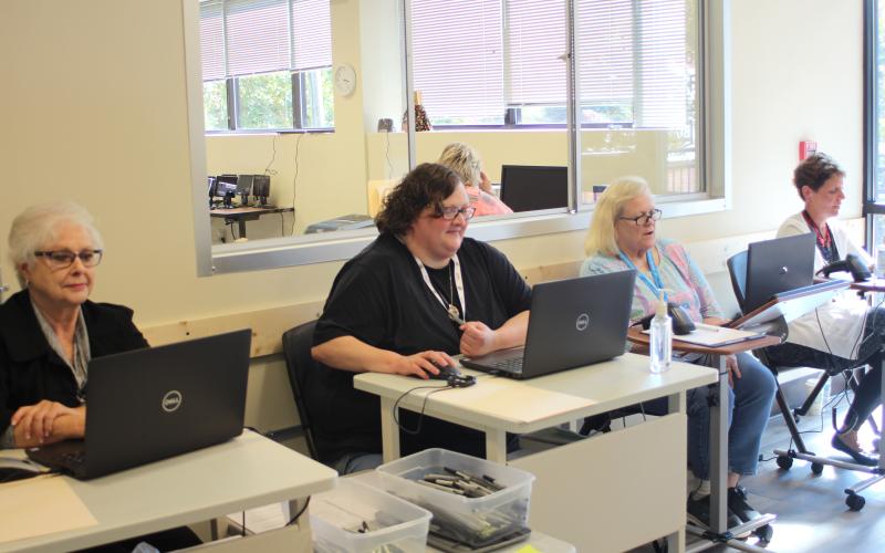 Megan Broome/The Clayton Tribune. Poll workers Ann D'Agostino, left, Amanda Burrell, Sandra Wood and Kay Townsend check in advance voters.