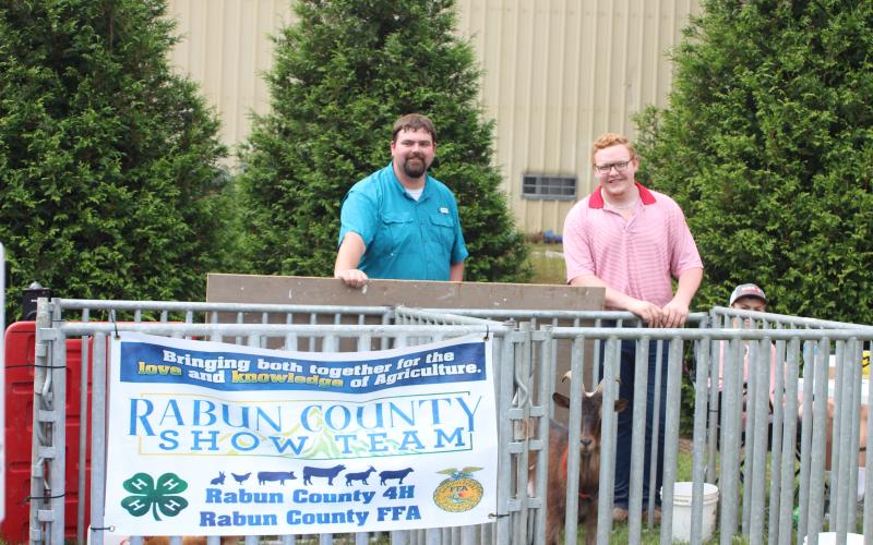 Megan Broome/The Clayton Tribune. Clay Brown, left, Carson Carpenter and Ethan Mazarky are with a goat named Brownie.