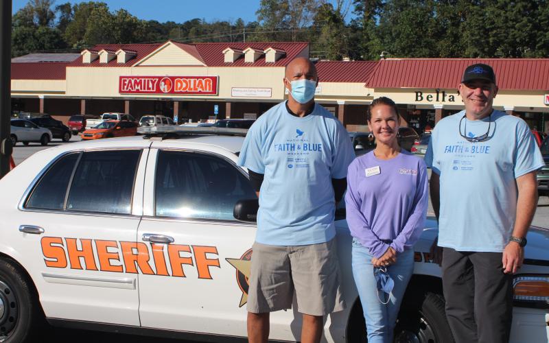 Megan Broome/The Clayton Tribune. James Brim, manager of the Food Bank Mountain Branch, Monica Blalock, director of community outreach for FAITH, and Rabun County Sheriff Chad Nichols participate in the Faith and Blue event last Saturday.
