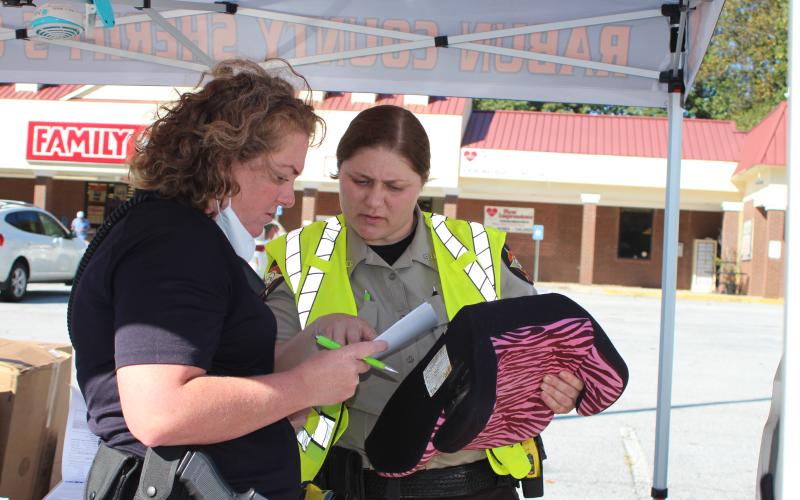Megan Broome/The Clayton Tribune. Deputy Ana Contreras and Lisa Thompson, coordinator for Safe Kids Rabun County, perform a car seat safety inspection.