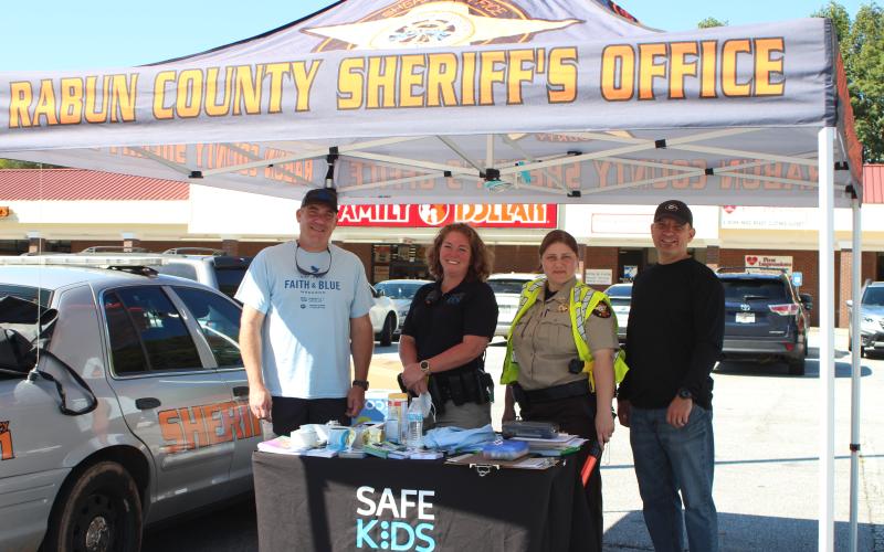 Megan Broome/The Clayton Tribune. Rabun County Sheriff Chad Nichols, left, Lisa Thompson, coordinator for Safe Kids Rabun County, Deputy Ana Contreras, and John Hutcheson, pastor of Tabernacle Baptist Church and chaplain for the sheriff's office, participate in the Faith and Blue event last Saturday.