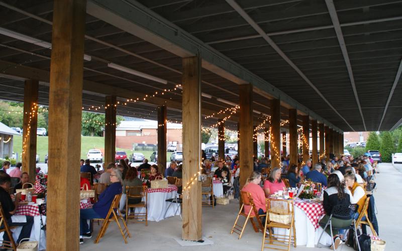 Photo courtesy of Elizabeth Adams. Guests enjoy a picnic style meal while listening to the Foxfire Boys at the Picnic for a Purpose.